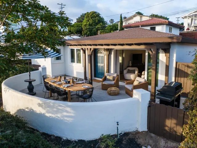 a view of a house with a chairs and table in a patio