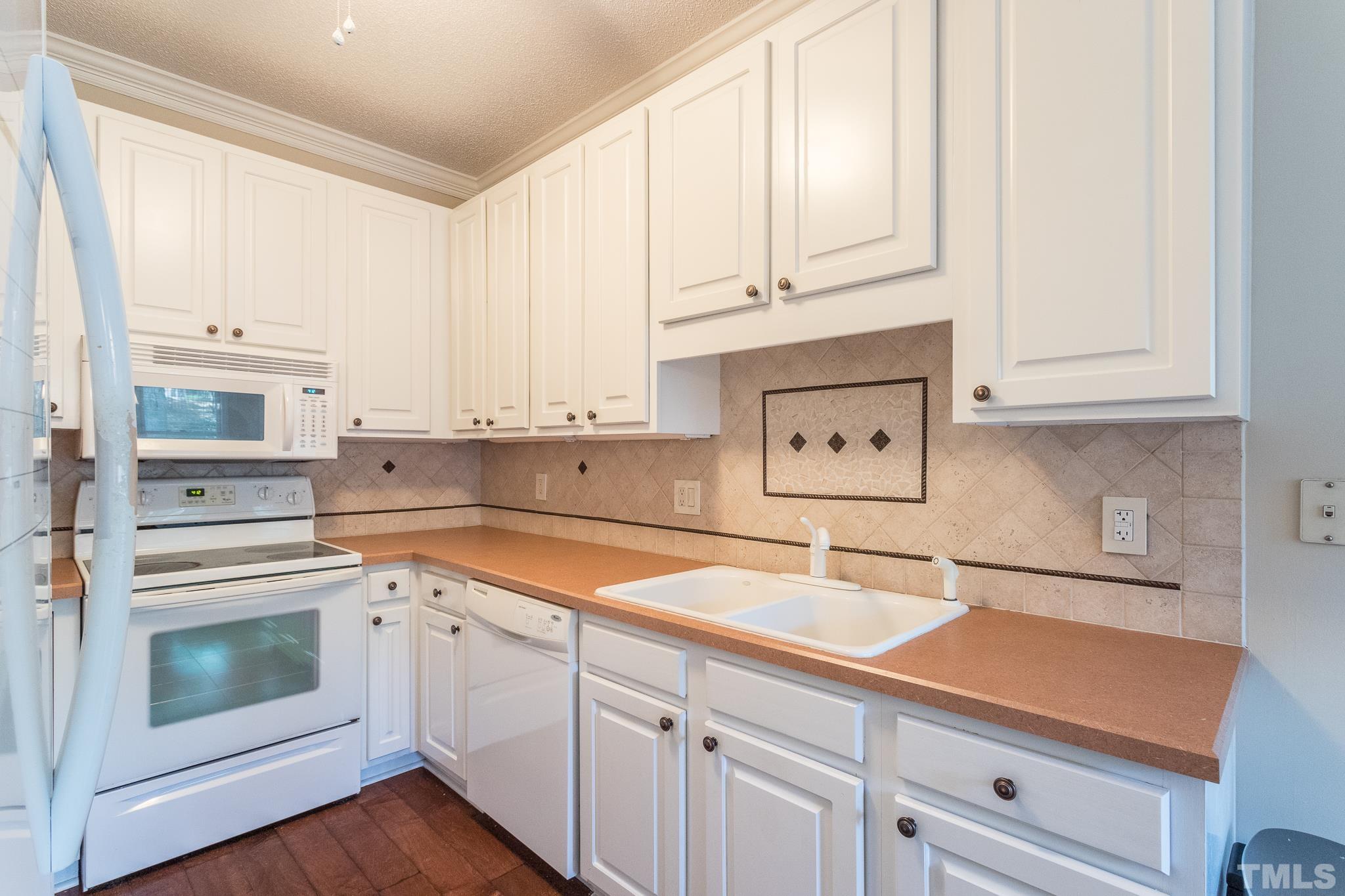 3722 Carnegie Lane Raleigh, NC 27612 - Photo 14 of 30 a kitchen with granite countertop white cabinets and white appliances