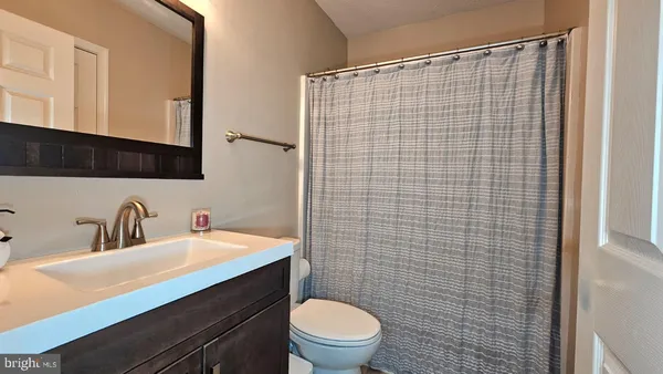 a bathroom with a sink a toilet and mirror