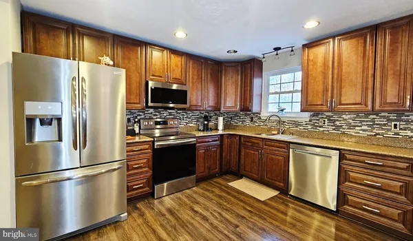 a kitchen with stainless steel appliances granite countertop a refrigerator stove microwave and sink
