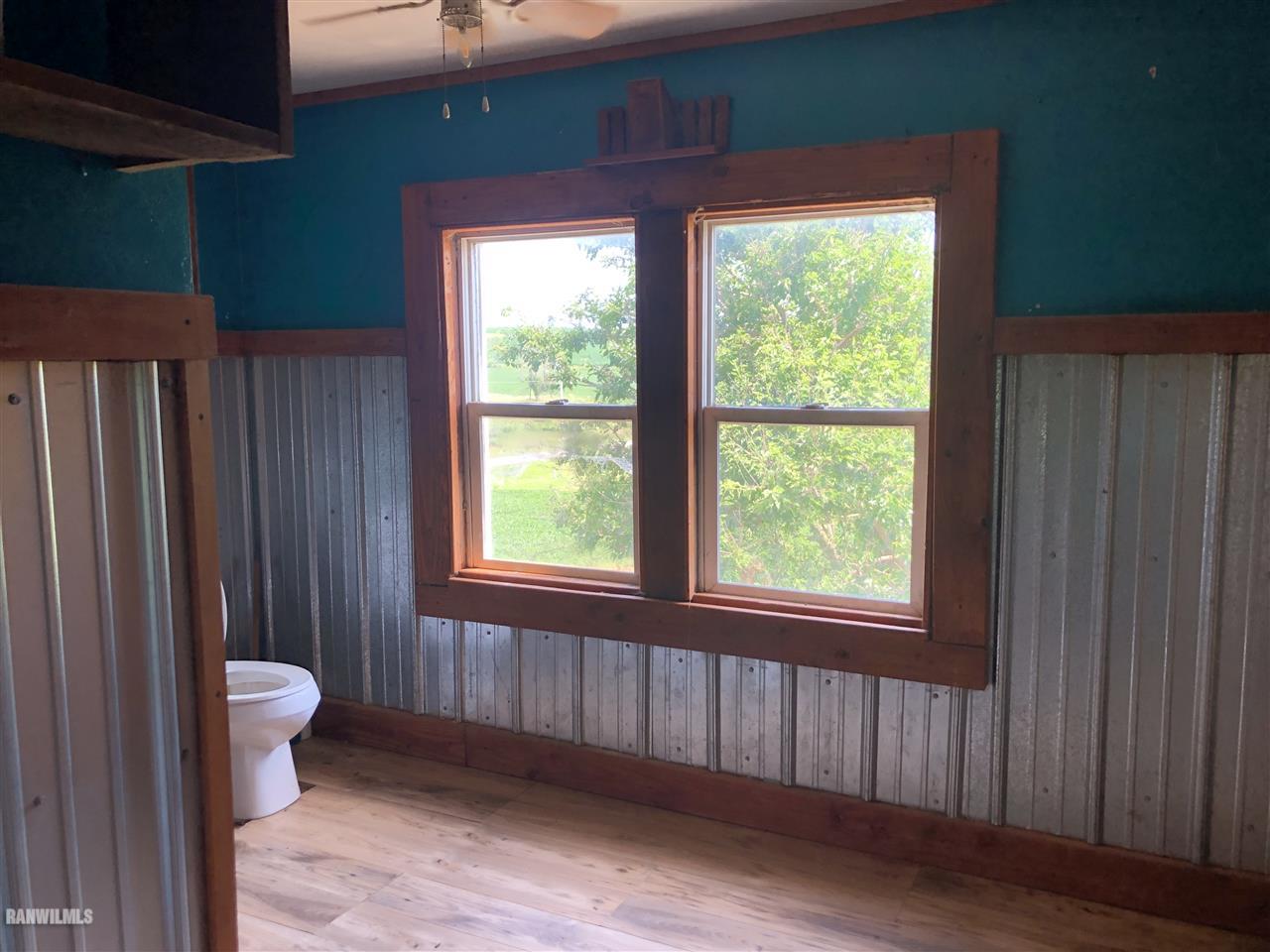 5998 Daggert Road Mount Carroll, IL 61053 - Photo 8 of 12 a view of an empty room with a window and wooden floor