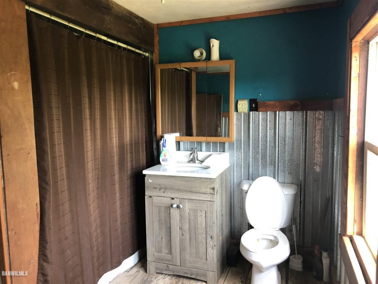 5998 Daggert Road Mount Carroll, IL 61053 - Photo 9 of 12 a bathroom with a toilet sink and mirror