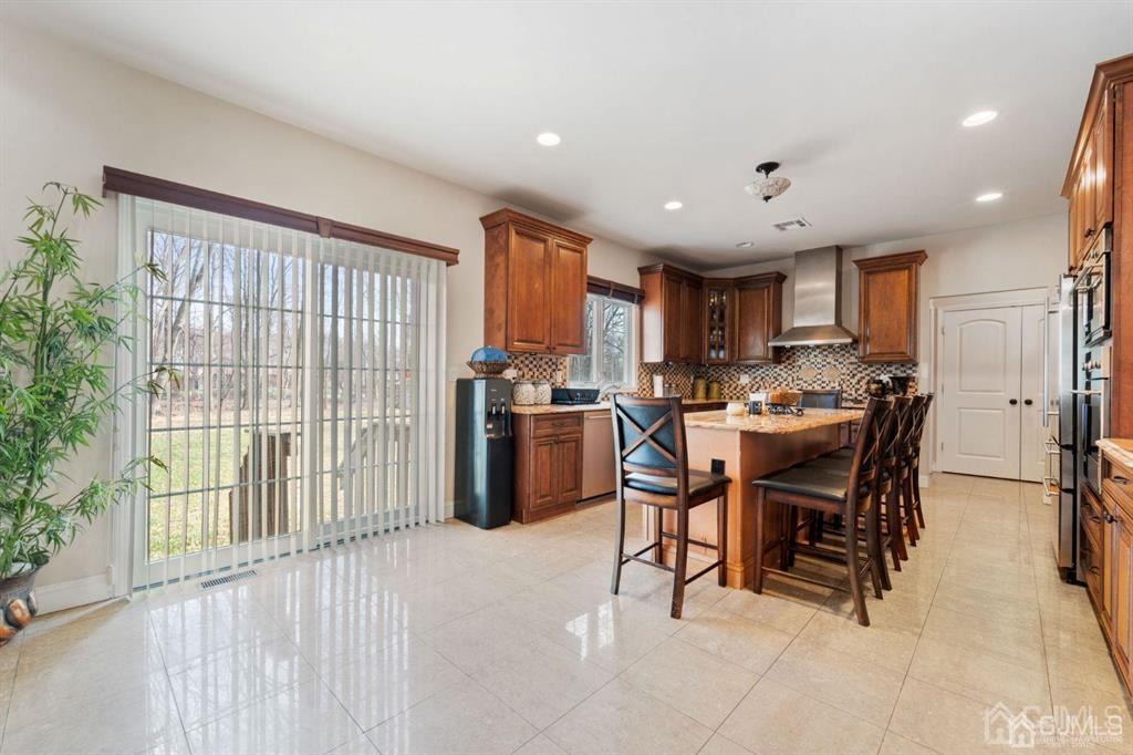 22 Utica Road Edison, NJ 08820 - Photo 11 of 28 a kitchen with a table chairs refrigerator and cabinets