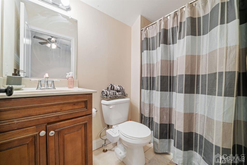 22 Utica Road Edison, NJ 08820 - Photo 16 of 28 a bathroom with a sink a toilet and shower curtain