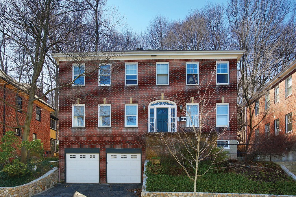 a front view of a house with a garden