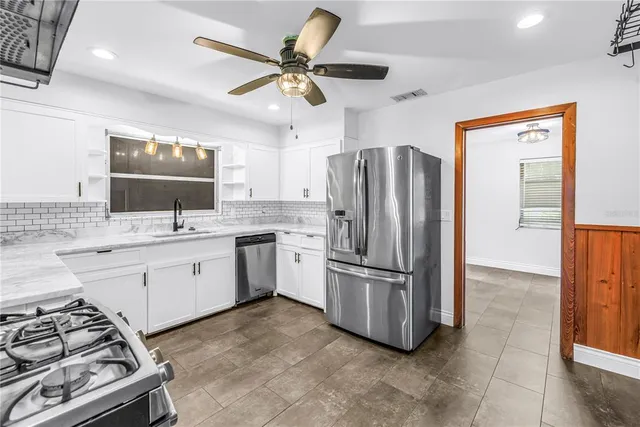 a kitchen with stainless steel appliances granite countertop a refrigerator and a sink
