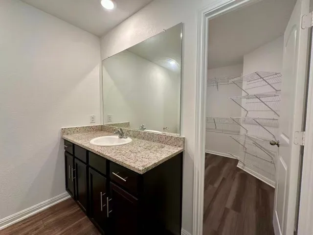 a bathroom with a granite countertop sink and a mirror
