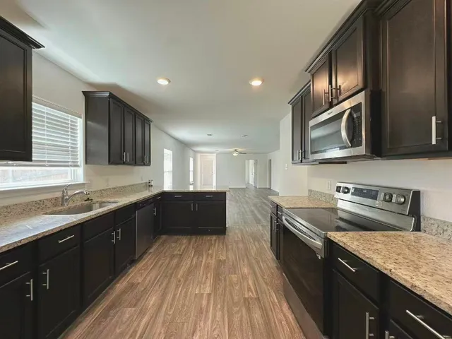 a kitchen with a sink stove top oven and microwave