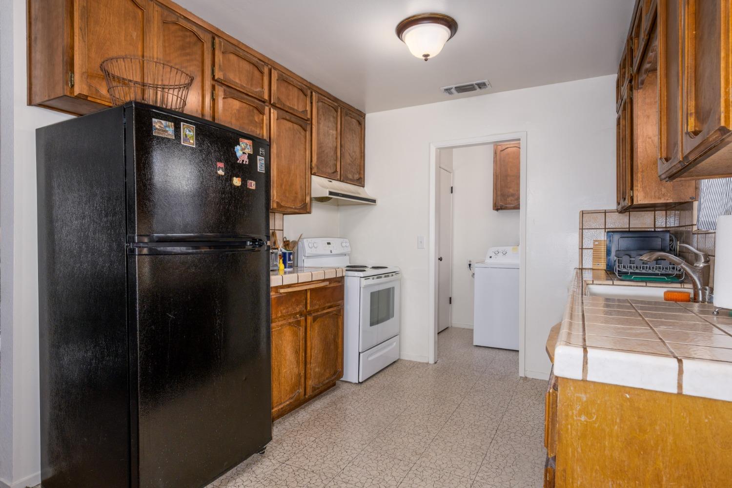 46011 Ming Circle Oakhurst, CA 93644 - Photo 13 of 37 a kitchen with stainless steel appliances a refrigerator sink and cabinets