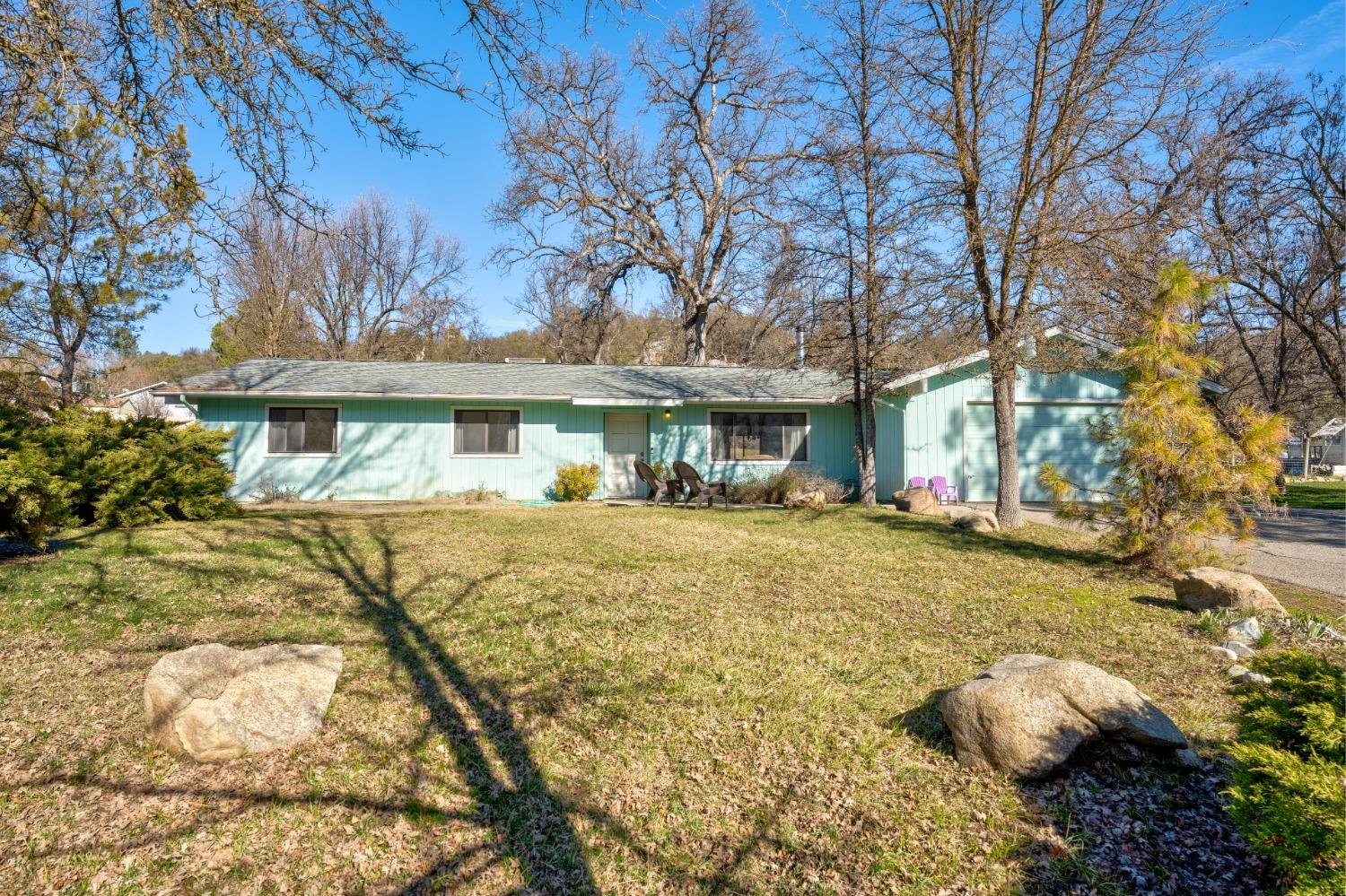 46011 Ming Circle Oakhurst, CA 93644 - Photo 2 of 37 a front view of a house with a yard garage and outdoor seating