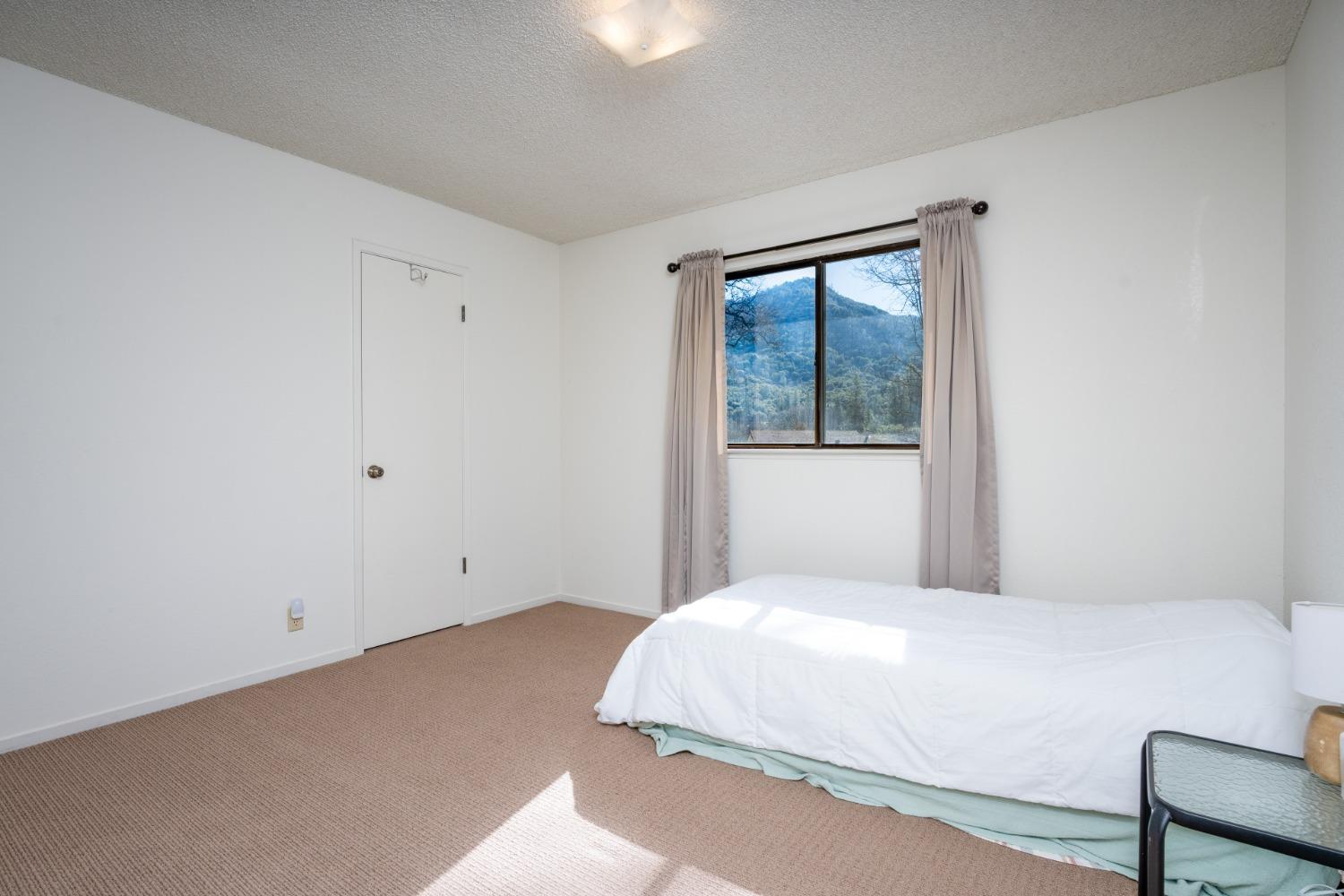 46011 Ming Circle Oakhurst, CA 93644 - Photo 21 of 37 a bedroom with a bed and a window