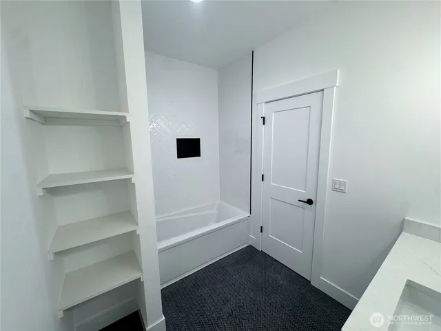 a view of kitchen with stainless steel appliances granite countertop a refrigerator a sink dishwasher a stove and a dining table with wooden floor