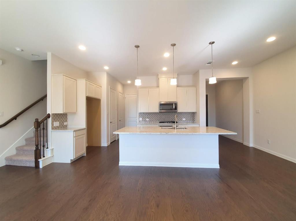 a view of kitchen with kitchen island stainless steel appliances sink refrigerator and stove
