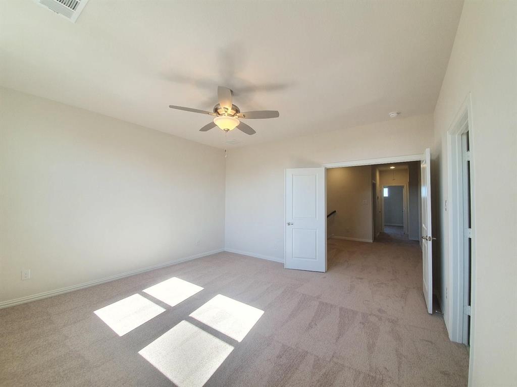 8286 Primrose Way Dallas, TX 75252 - Photo 13 of 25 an empty room with chandelier fan and windows