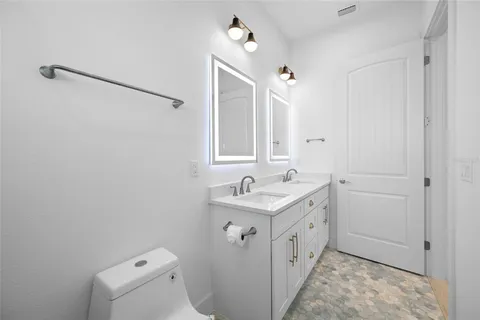 a bathroom with a granite countertop sink a toilet and shower
