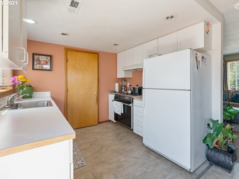 8106 Southeast Knight Street Portland, OR 97206 - Photo 4 of 29 a kitchen with a refrigerator a stove top oven and a dining table