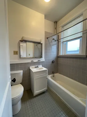 a bathroom with a sink mirror vanity bathtub and a toilet