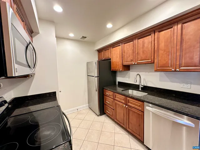 a kitchen with stainless steel appliances granite countertop a sink stove and cabinets