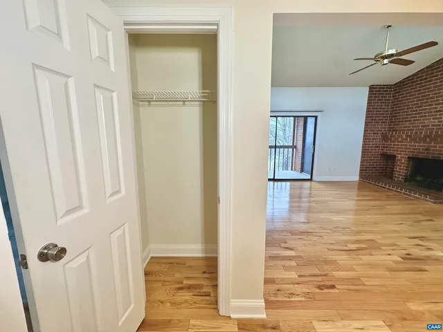 a view of a hallway with wooden floor and staircase
