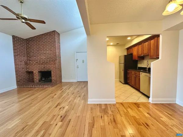 a view of empty room with wooden floor and fireplace