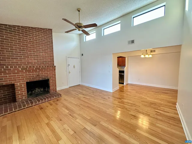 a view of empty room with fireplace and wooden floor