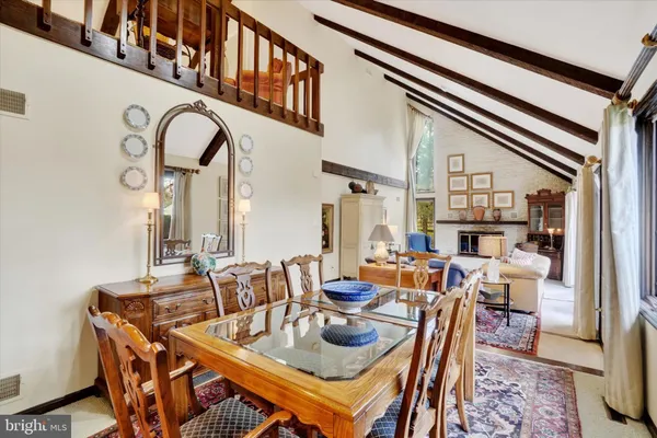 a living room with stainless steel appliances furniture a dining table and kitchen view