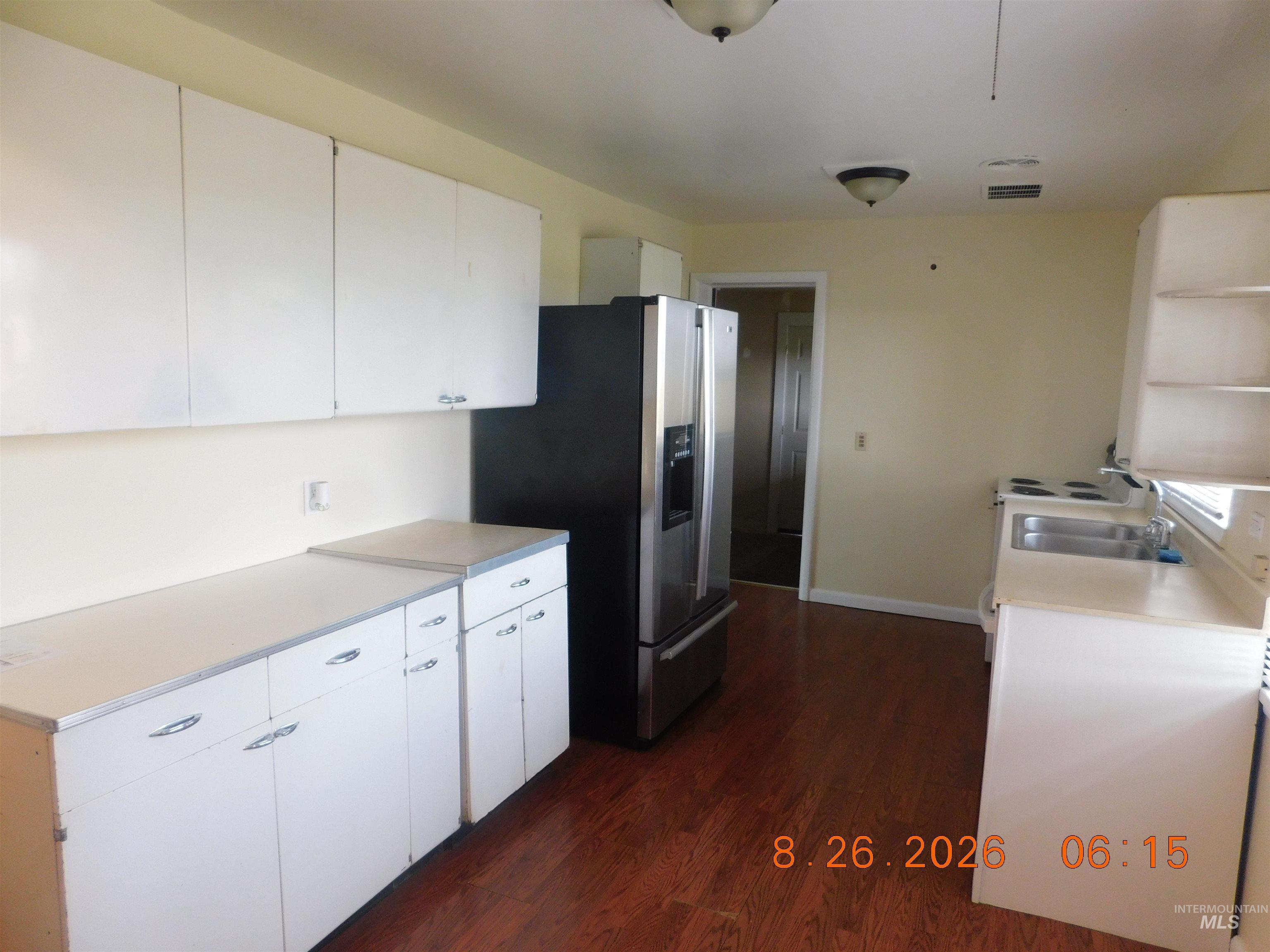 2115 North Galena Road Council, ID 83612 - Photo 12 of 18 Wood-finish flooring with white cabinetry, stainless steel refrigerator, and built-in electric range