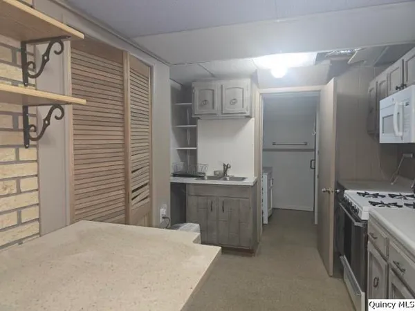 a kitchen with stainless steel appliances kitchen island a refrigerator sink and cabinets