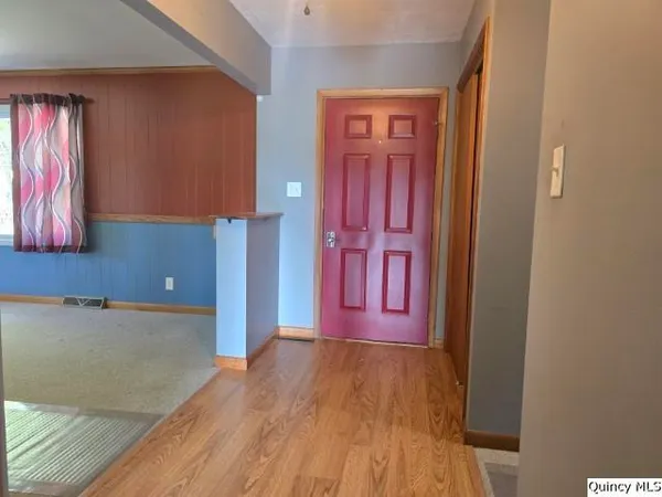 a view of a room with wooden floor and windows