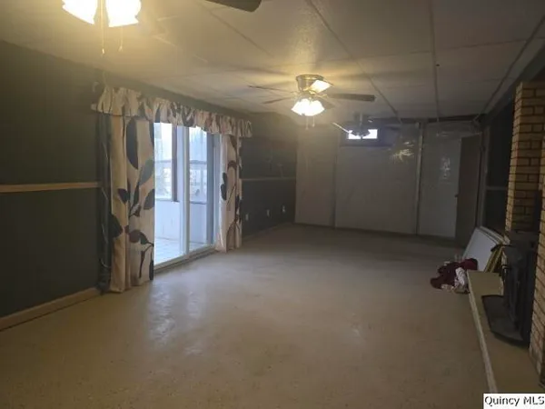 an empty room with stairs and windows