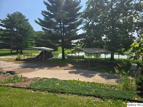 a view of a lake with a yard and a wooden fence
