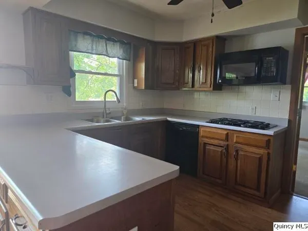a kitchen with stainless steel appliances granite countertop a sink a stove and a microwave oven