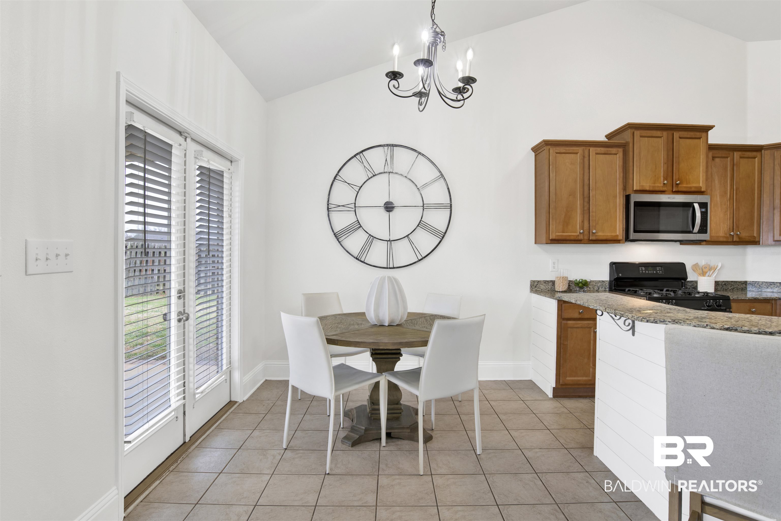 25350 Spindle Lane Daphne, AL 36526 - Photo 12 of 32 Kitchen featuring light tile patterned flooring, high vaulted ceiling, hanging light fixtures, a notable chandelier, and black gas range