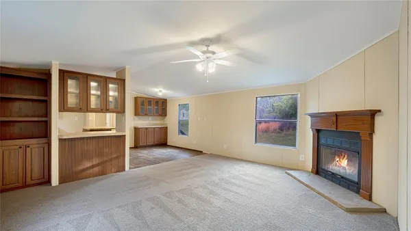 a view of an empty room with a fireplace and a window