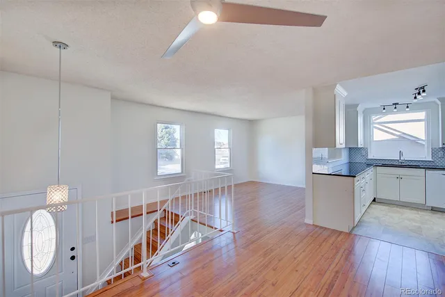 a kitchen with granite countertop white cabinets and a sink