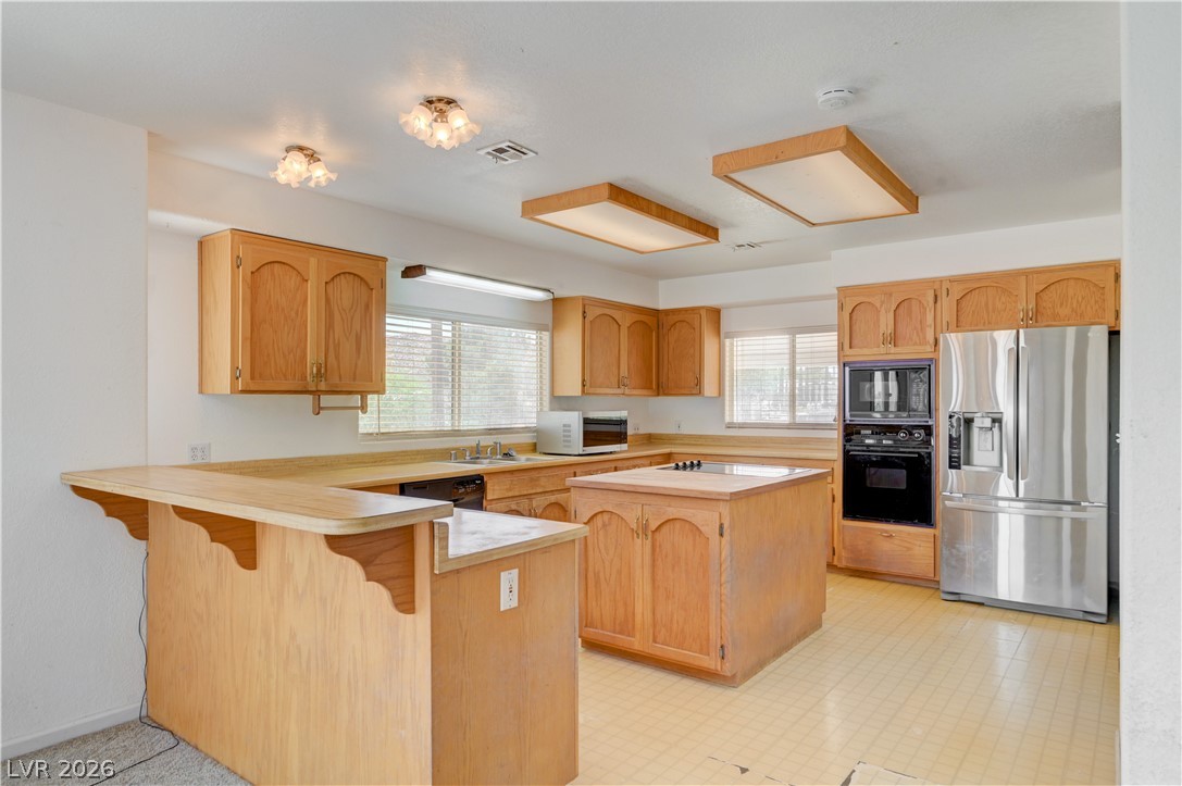 590 East Encinitas Street Searchlight, NV 89046 - Photo 2 of 39 This kitchen features a practical layout, wooden cabinetry, and modern stainless steel appliances.