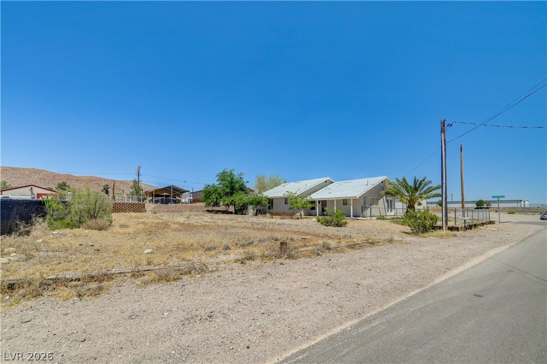 590 East Encinitas Street Searchlight, NV 89046 - Photo 23 of 39 This desert dwelling features expansive outdoor space and mountain views under a vast blue sky.