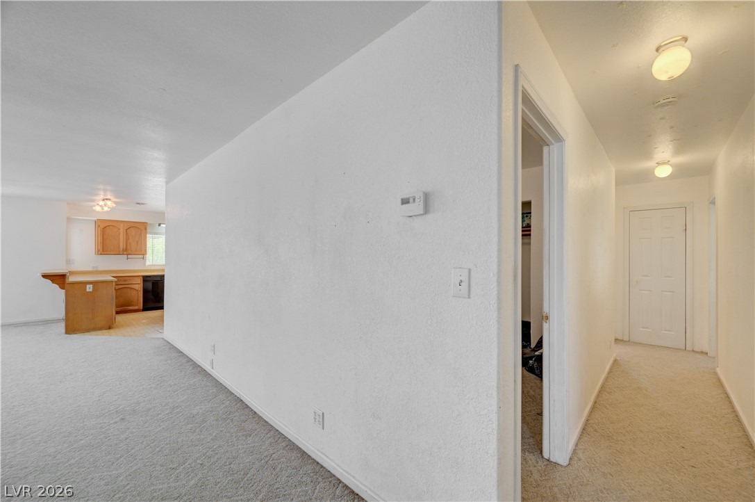 590 East Encinitas Street Searchlight, NV 89046 - Photo 39 of 39 An inviting interior with soft carpeting offers a glimpse into an adjacent kitchen and hallway.