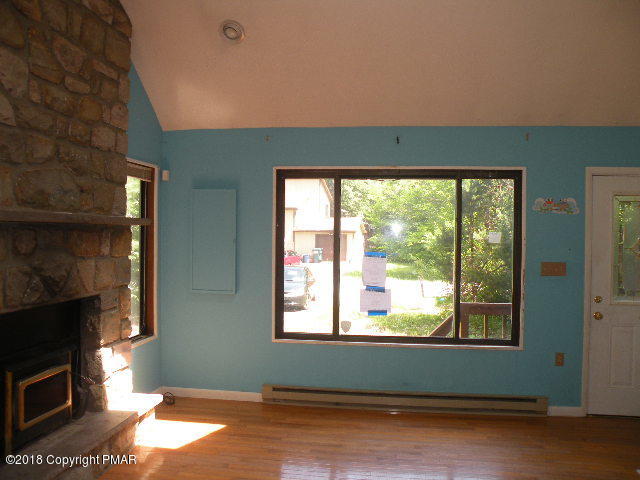 703 Edgewood Road Tobyhanna, PA 18466 - Photo 6 of 17 a living room with a fireplace and a floor to ceiling window