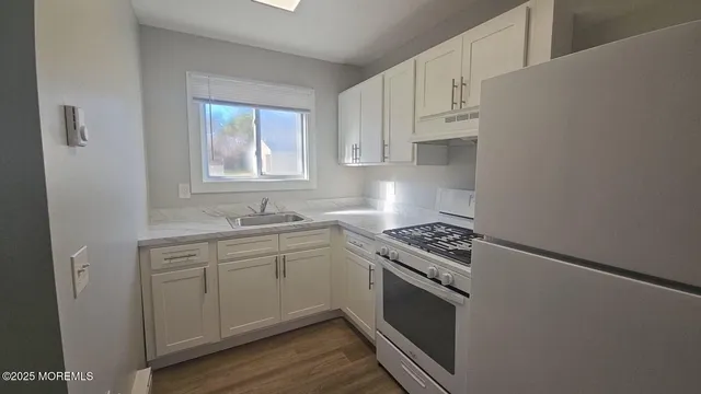 a kitchen with cabinets appliances and a window