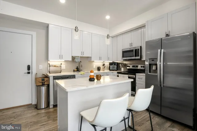 a kitchen with stainless steel appliances a refrigerator and a stove top oven