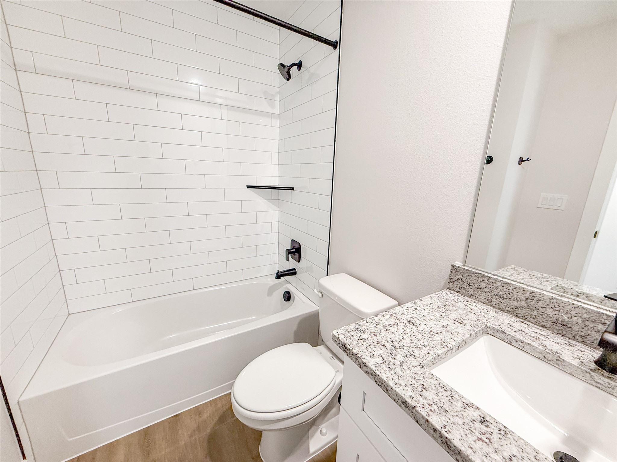 5605 Mobeetie Loop Bee Cave, TX 78738 - Photo 11 of 23 a bathroom with a granite countertop toilet a sink and bathtub