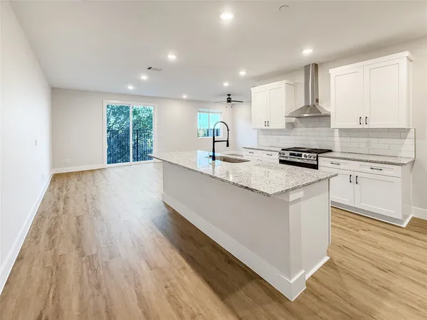 a kitchen with stainless steel appliances granite countertop wooden cabinets a stove a sink and a microwave