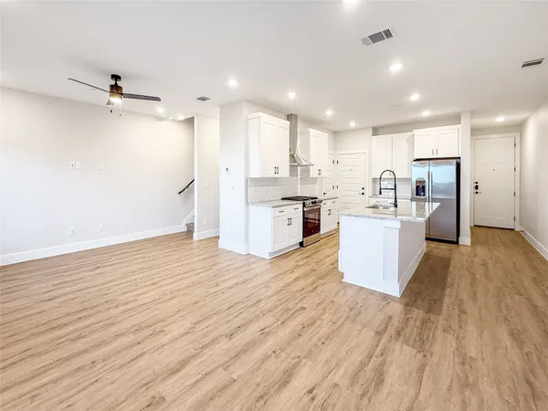 a view of kitchen view wooden floors appliances and cabinets