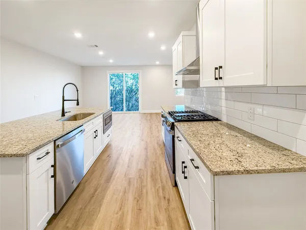 a kitchen with granite countertop sink and cabinets