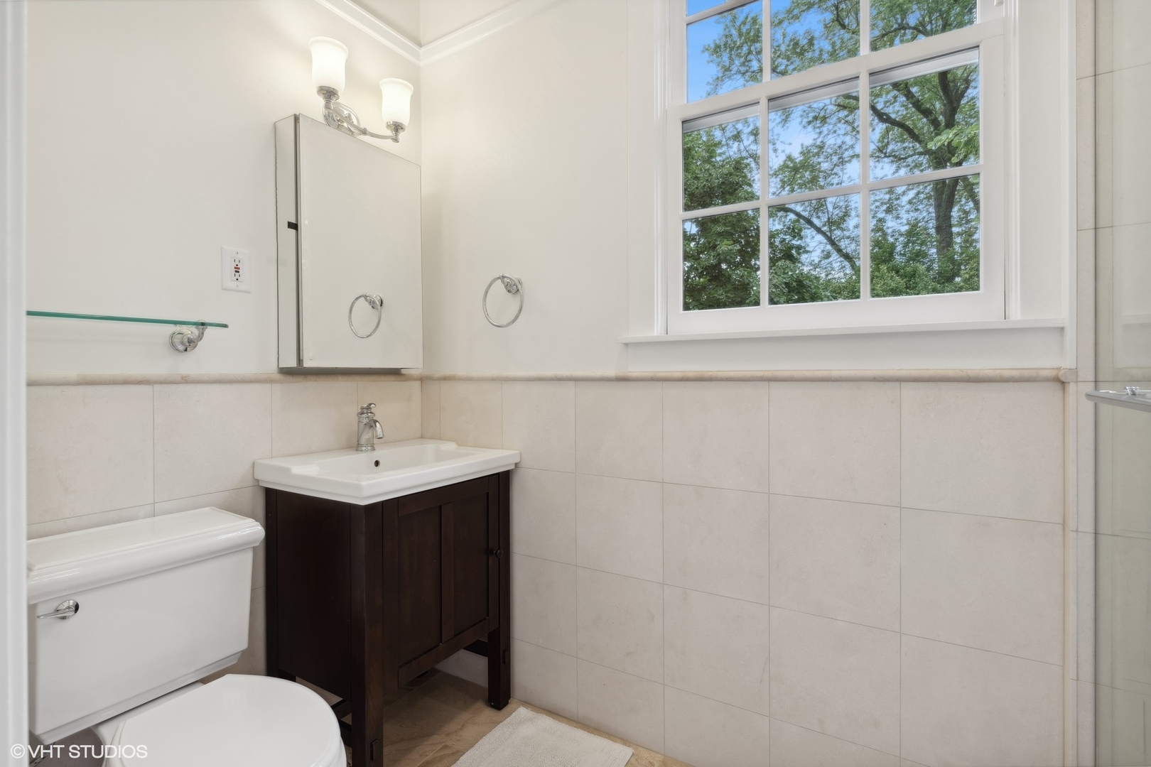 720 Willow Road Winnetka, IL 60093 - Photo 34 of 60 a bathroom with a toilet a sink a mirror and a window