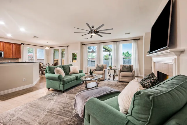 a living room with furniture a flat screen tv and a fireplace