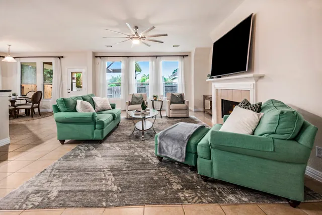 a living room with furniture a flat screen tv and a fireplace