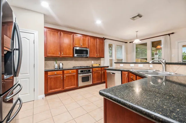 a kitchen with stainless steel appliances granite countertop a sink stove and refrigerator