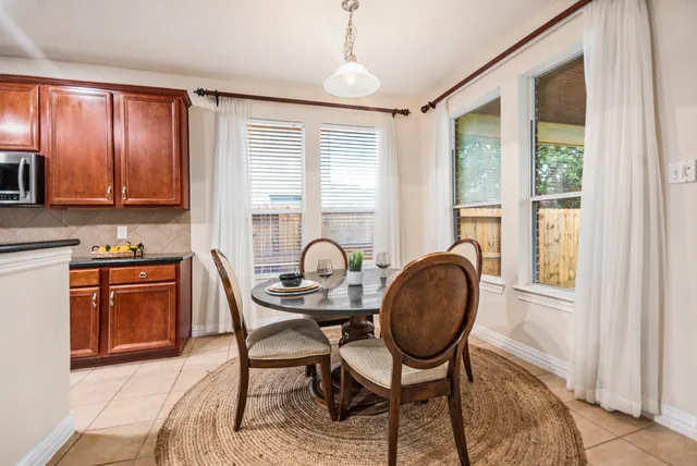 a kitchen with granite countertop a stove a table and chairs in it